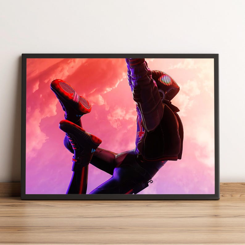 K&ouml;nnte beinhalten: Gerahmter Kunstdruck mit einem Superhelden in dynamischer Pose vor einem farbenfrohen Himmel. Die Figur tr&auml;gt einen schwarzen und roten Anzug mit einer markanten Maske. Das Kunstwerk wird in einem schwarzen Rahmen pr&auml;sentiert.