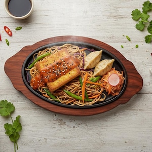 以下が含まれることがあります： 麺、豆腐、餃子を使ったアジア風料理の湯気の立つお皿。豆腐には赤いソースとゴマがトッピングされています。グリーンビーンズ、ニンジン、キムチが添えられています。パクチーと赤唐辛子で飾られています。