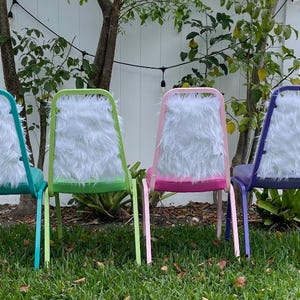 May include: Four chairs with white faux fur seat backs. The chairs are painted in different colors: teal, green, pink, and purple.