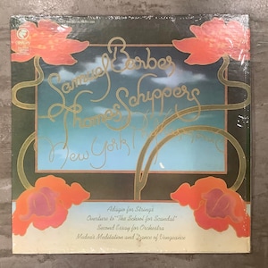 May include: A vintage vinyl record album cover featuring the names Samuel Barber and Thomas Schippers in gold script. The cover has a blue and gold background with orange floral accents and the text "New York!". The album includes "Adagio for Strings".
