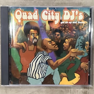 May include: A CD case featuring the album art for "Quad City DJ's get on up and dance." The artwork depicts a crowd of people dancing, with several figures in the foreground. The CD case is in a clear plastic case.