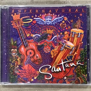 May include: A white ceramic mug with a black handle and the text "But First, Coffee" in a bold, black font. The mug is set against a blurred background, highlighting its clean design.