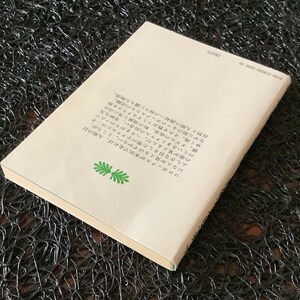 May include: The back cover of a book with a white background and black text. The text describes a story about a boy who can see the mythical creatures called "コロポックル".