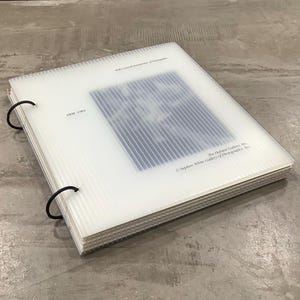 May include: A white plastic photo album with black ring binders. The album contains a blue and white image with vertical lines. Text on the album reads "Will Connell Interpretations of Intimations", "1956-1961", and "The Hasted Gallery, Inc. © Stephen White Gallery of Photographs, Inc."