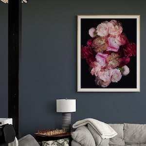 May include: A framed print of a floral arrangement featuring pink and red flowers against a black background. The flowers are arranged in a symmetrical pattern, creating a visually appealing and artistic composition.