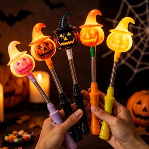 May include: Five light-up Halloween wands featuring jack-o'-lantern heads wearing witch hats. The wands have flexible metal stems and plastic handles in purple, black, orange, and yellow. Each pumpkin head glows with an internal light.