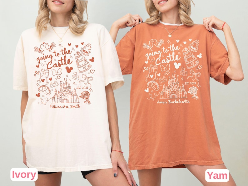 May include: Two t-shirts, one ivory and one yam-colored, feature a whimsical design with the text "going to the Castle." The design includes a castle, wedding rings, champagne glasses, and the text "Future Mrs. Smith" and "Amy's Bachelorette."