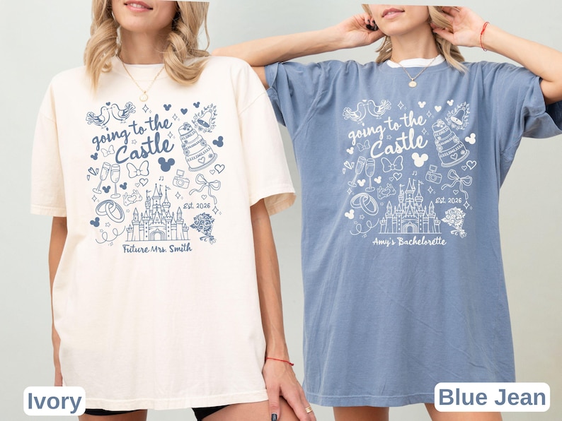 May include: Two t-shirts, one ivory and one blue, with a whimsical design. The shirts feature the text "Going to the Castle" with a castle illustration, doves, and other wedding-themed graphics. One shirt says "Future Mrs. Smith" and the other says "Amy's Bachelorette".