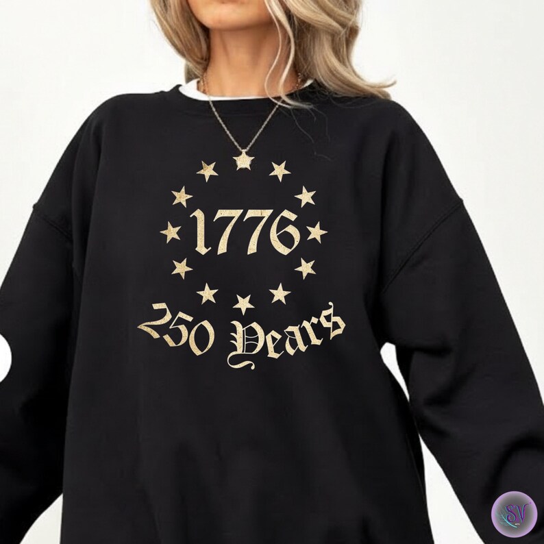 May include: Black sweatshirt with a white collar featuring gold text and star accents. The design includes the year "1776" encircled by stars, with "250 Years" below. The sweatshirt is a casual garment.