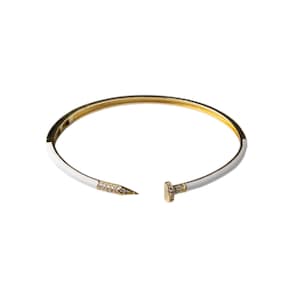 May include: Gold-tone bracelet with a white enamel finish. The bracelet features a nail head design with sparkling accents. The open design allows for easy wear. A stylish piece of jewellery.
