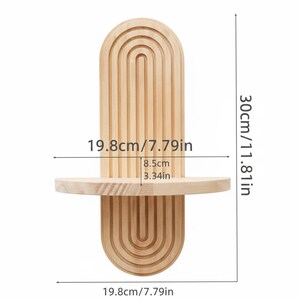 Op de afbeelding: Een lichtgekleurd houten wandrek met een boogvormig ontwerp. De plank is 19,8 cm breed en 30 cm hoog. De plank heeft een kleine, afgeronde plank van 8,5 cm diep. De plank is gemaakt van lichtgekleurd hout.