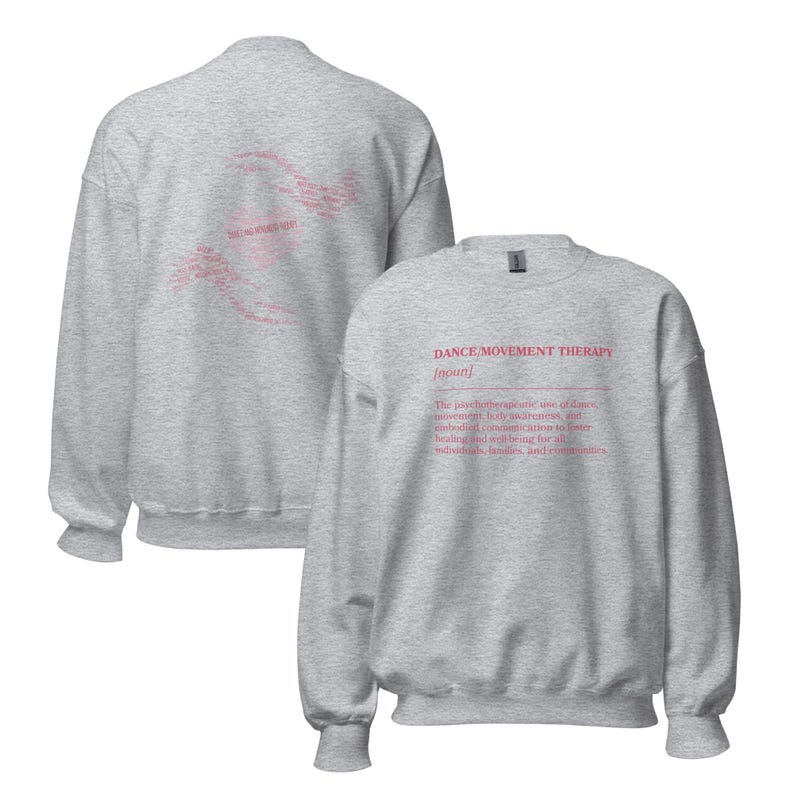 May include: A heather gray sweatshirt with the text "DANCE/MOVEMENT THERAPY" in pink on the front and back. The back of the sweatshirt has a pink design. The front of the sweatshirt has a definition of dance movement therapy.