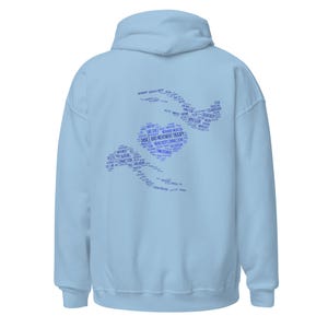 May include: A light blue hoodie with a hood and long sleeves. The back of the hoodie features a blue graphic composed of words related to dance and movement therapy, arranged in a stylized shape.