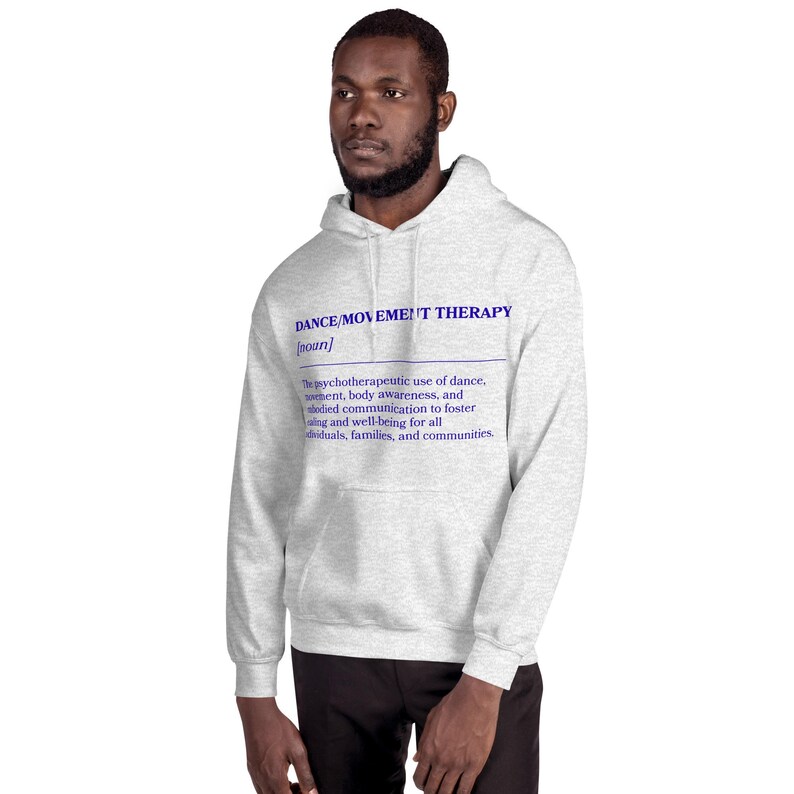 May include: A light gray hoodie with the text "DANCE/MOVEMENT THERAPY" in blue. The definition below describes the psychotherapeutic use of dance, movement, body awareness, and communication for well-being.