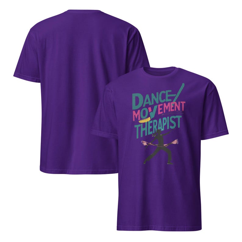 May include: Purple t-shirt with the text "DANCE MOVEMENT THERAPIST" in teal, pink, and yellow. A silhouette of a person dancing is below the text. The back of the shirt is plain purple.