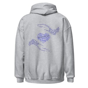 May include: A light gray hoodie with a hood and long sleeves. The back of the hoodie features a blue word cloud design in the shape of a person dancing, with the words "Dance and Movement Therapy" prominently displayed.