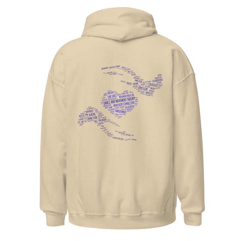 May include: A cream-colored hoodie with a hood and long sleeves. The back features a blue graphic composed of words related to dance and movement therapy, including "Safe Space" and "Expression."