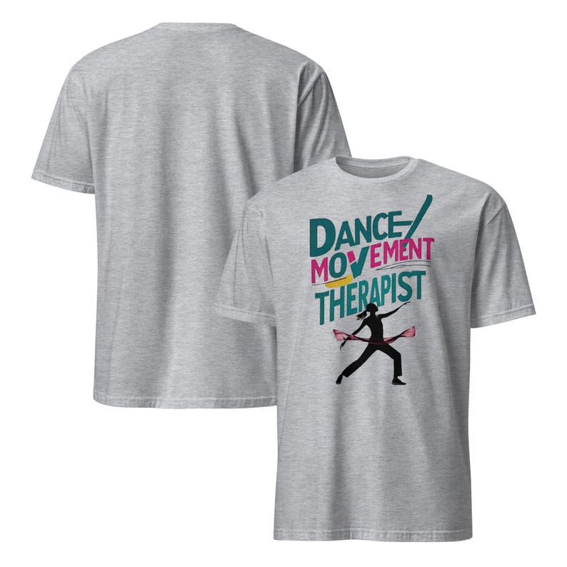 May include: Two light gray t-shirts. The front shirt has the words "DANCE MOVEMENT THERAPIST" in teal, pink, and yellow, with a black silhouette of a person dancing. The back of the shirt is plain.