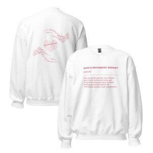 May include: White sweatshirt with the text "DANCE/MOVEMENT THERAPY" in red. The back of the sweatshirt features a heart-shaped design with related words. The sweatshirt's description includes the definition of dance/movement therapy.