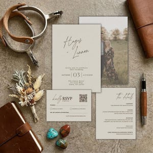 May include: A wedding invitation suite with a neutral color palette. The suite includes an invitation, RSVP card, and details card. The invitation features the names "Hayes & Lennon" and the date "October 03". A leather-bound notebook, pen, and decorative items are also present.