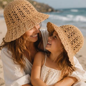Puede incluir: Dos sombreros de pescador de ganchillo en color beige con un delicado patrón calado. Los sombreros presentan una copa redondeada y un ala flexible inclinada hacia abajo, confeccionados con hilo de fibra natural claro y texturizado.