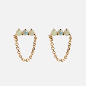 May include: A pair of gold-colored earrings. Each earring features three small, round, opalescent stones set in a row, connected to a delicate chain that dangles below. The earrings are presented against a plain, light background.