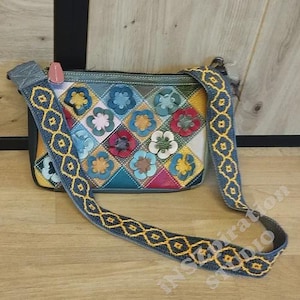 Puede incluir: Bolso bandolera multicolor con diseño patchwork y aplicaciones florales. El bolso tiene una correa de mezclilla azul con bordados geométricos amarillos. El cuerpo del bolso es una mezcla de colores, incluyendo azul, rosa, amarillo y blanco.