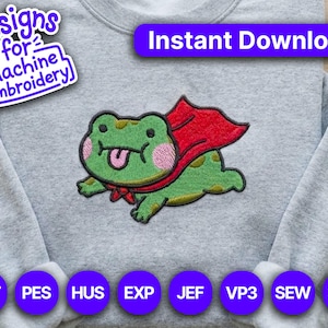 Puede incluir: Una sudadera gris con un diseño de bordado a máquina de una rana verde con una capa roja. La rana tiene la lengua fuera. El texto incluye "Designs for Machine Embroidery" y "Instant Download!" con opciones de formato de archivo.