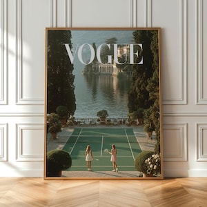Könnte beinhalten: Ein gerahmtes Vogue-Magazin-Cover. Das Bild zeigt einen Tennisplatz mit zwei Personen beim Tennisspielen, vor dem Hintergrund eines Sees und eines Gebäudes. Das Wort "VOGUE" steht oben.