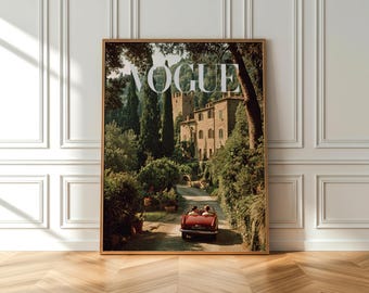 May include: A framed Vogue magazine cover featuring a scenic Italian landscape. The image showcases a red convertible driving on a road towards a stone building, surrounded by lush greenery and tall trees. The Vogue logo is prominently displayed at the top.