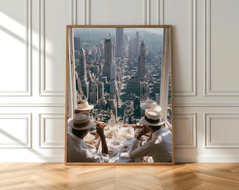 May include: A framed photograph depicts a city view with people seated at a table, wearing white shirts and hats. The table is set with dishes and drinks. The city skyline features tall buildings and a bright sky.