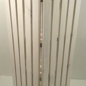 May include: White wooden corner shelf with a slatted design. The shelf is made of unfinished wood and has a rustic look.
