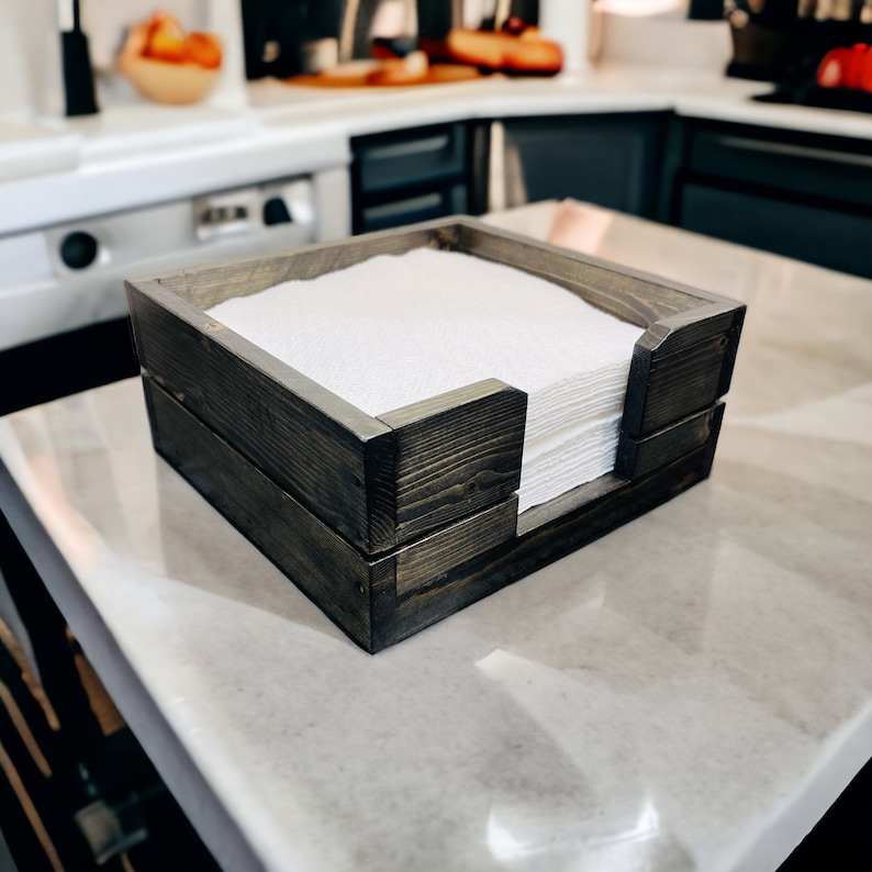 wooden standard size napkin holder.  Farmhouse style, square shaped with opening in front for easily grabbing for a napkin.  Color shown is ebony stain.