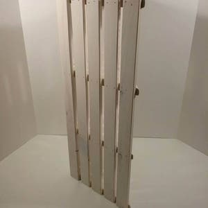 May include: White wooden pallet with a rustic look. The pallet is made of unfinished wood and has a natural wood grain. The pallet is perfect for adding a touch of rustic charm to any home or garden.