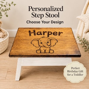 May include: A wooden step stool with a dark brown stained top and white legs. The top surface features the engraved name Harper above a line art illustration of a baby elephant. Text above the stool reads Personalized Step Stool Choose Your Design.