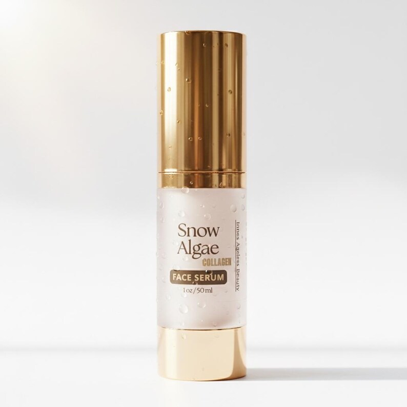 "A gold and frosted glass bottle of Innes Ageless Beauty Snow Algae Collagen Face Serum surrounded by water splashes and a swatch of the clear, hydrating peptide gel."