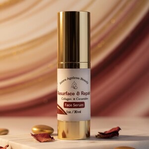 May include: A gold and white face serum bottle with the text "Resurface & Repair" and "Face Serum." The bottle is on a white marble surface with gold accents and dried rose petals.