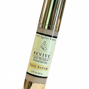 Revive anti wrinkle resurfacing face serum in gold airless pump bottle with lightweight serum texture for mature skin, glow support, and smoother looking complexion