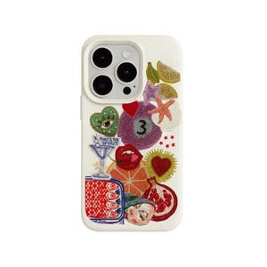 Può includere: Custodia per telefono bianco sporco con disegni ricamati colorati. Presenta un bicchiere da martini con testo, un cuore rosso, il numero 3, labbra e altri elementi stravaganti. La custodia ha un ritaglio per la fotocamera.