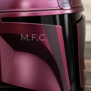 Pu&ograve; includere: Primo piano di un casco bordeaux con dettagli neri. Il casco ha una finitura metallica e le lettere "M.F.C." sono visibili sul lato. Il design presenta forme angolari e un'estetica elegante e moderna.