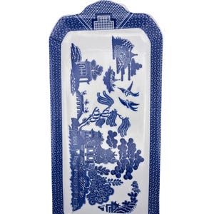 May include: Rectangular serving tray with a blue and white Willow pattern design. The tray has a white center with a detailed landscape scene and a blue patterned border. Decorative and functional.