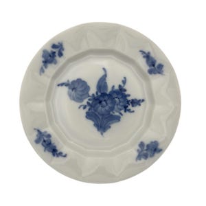 May include: White porcelain plate with a scalloped edge and blue floral pattern. The plate has a central bouquet and smaller floral accents around the rim. A classic piece for serving or display.