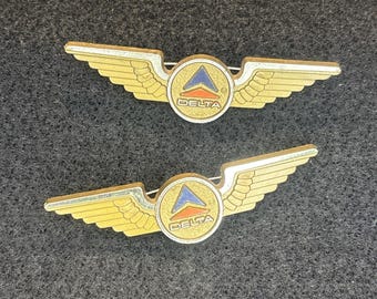 2 pines vintage de Delta Airlines con forma de ala, tono dorado, insignia de aviación, logotipo publicitario, plástico
