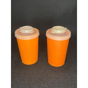 May include: A white ceramic mug with a black handle and the text "But First, Coffee" in a handwritten style. The mug is on a white surface. The mug is approximately 4 inches tall.