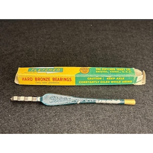 May include: A vintage glass cutter with a teal handle and a gold tip, next to its original yellow and green box. The box reads "FLETCHER HARD BRONZE BEARINGS" and "GOLD TIP".