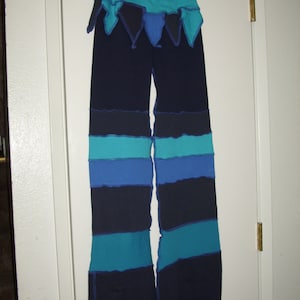May include: Blue and teal striped pants with a layered design. The pants have a blue waistband and a teal and black ruffle at the top.