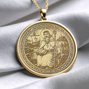 May include: Gold pendant necklace with a detailed engraved image of a religious figure. The round pendant has an ornate border and is suspended from a delicate chain. The pendant depicts a figure with a staff and book.