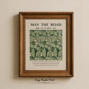 Op de afbeelding: Ingelijste print met de tekst "MAY THE ROAD RISE UP TO MEET YOU". De print heeft een groen en wit bloemenpatroon en een citaat over zegeningen. De lijst heeft een warme bruine kleur.