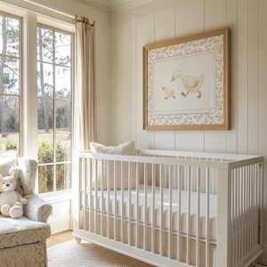 Pode incluir: Um quarto de crian&ccedil;a com um ber&ccedil;o branco, uma poltrona estampada e uma impress&atilde;o emoldurada de um pato e um patinho. O quarto tem janelas grandes com luz natural e paredes e cortinas em tons neutros. Um coelhinho de pel&uacute;cia est&aacute; na poltrona.