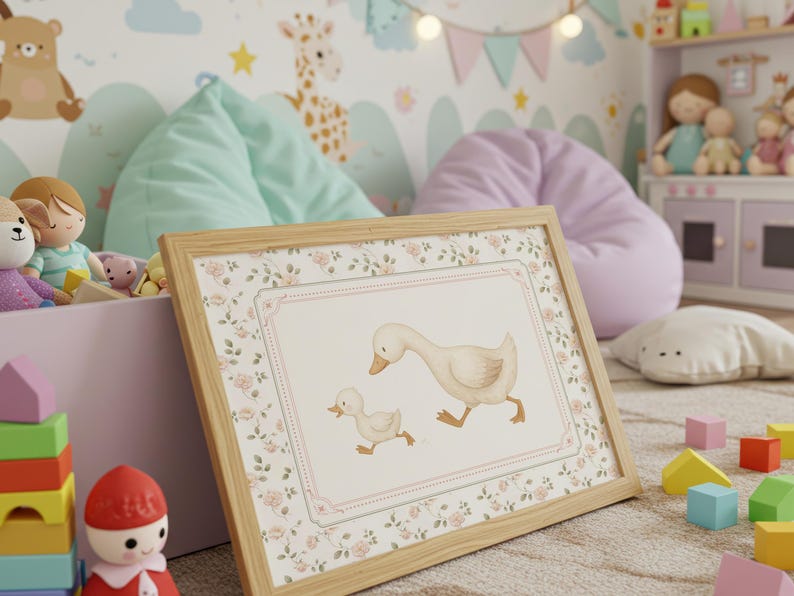 Pode incluir: Uma impress&atilde;o emoldurada com uma ilustra&ccedil;&atilde;o em aquarela de um ganso e um ganso. A obra de arte tem uma borda floral e uma moldura de madeira clara. A imagem est&aacute; em um quarto infantil com brinquedos e itens decorativos.